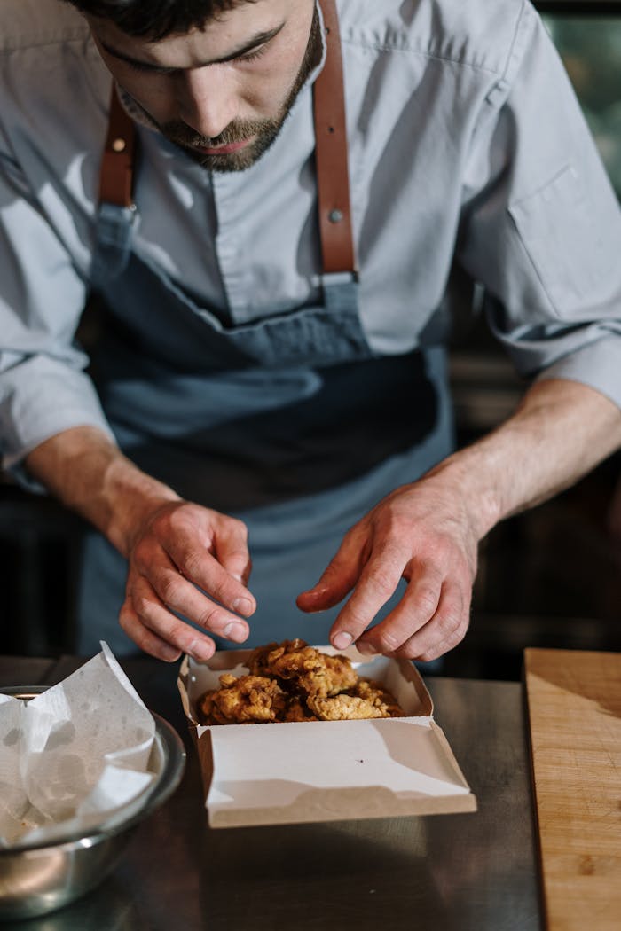 Person in Blue Button Up Shirt Holding Brown Food